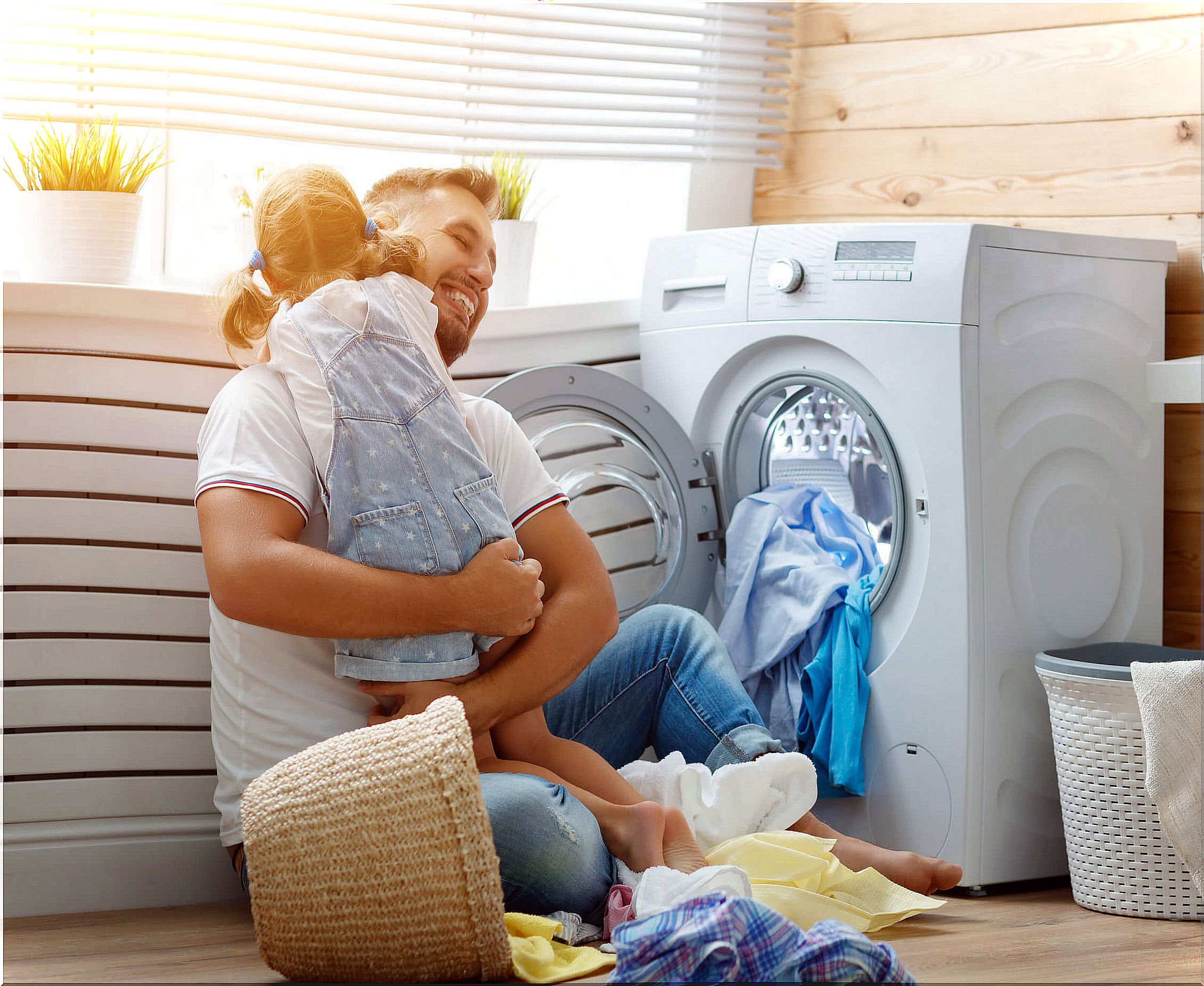 Father with his daughter putting a washing machine as part of the house rules.