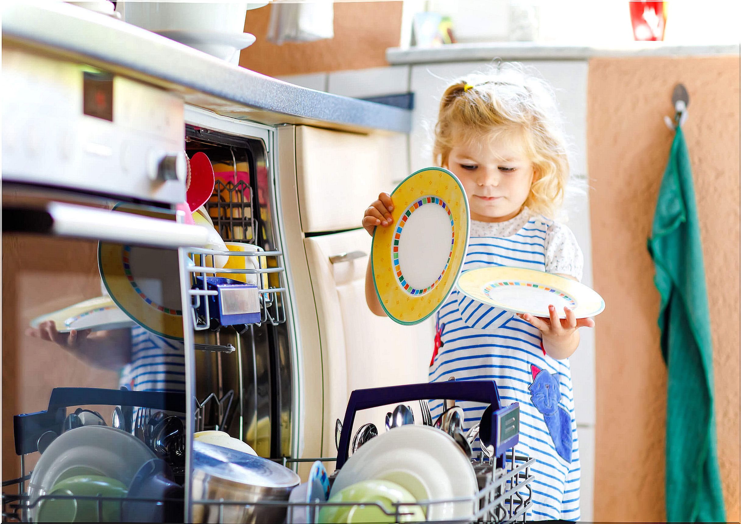 Little girl putting the dishwasher.