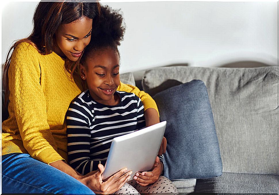 Mother and daughter with a tablet deciding which of the all proposed educational applications they decide to use.