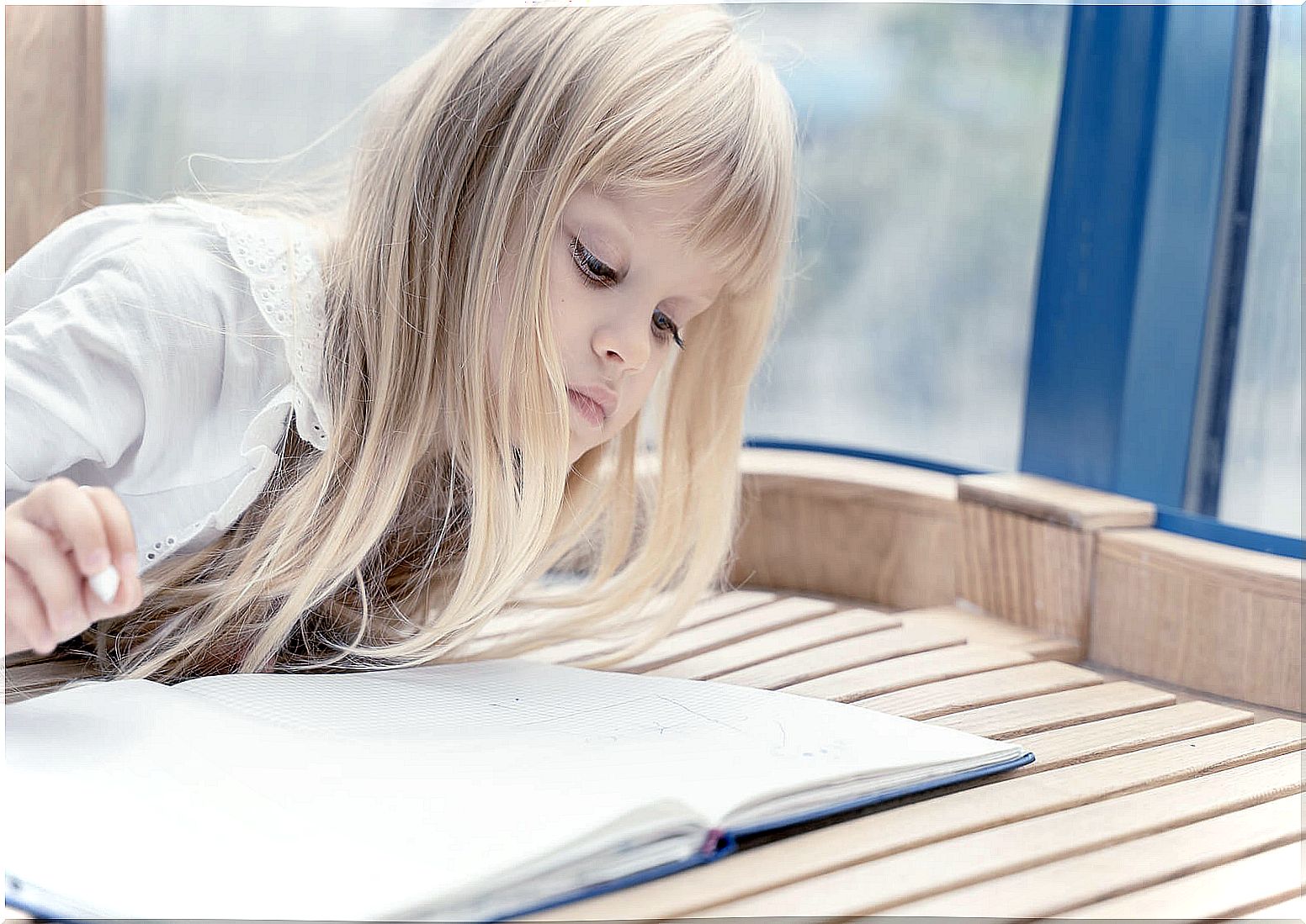 Girl thinking about handwriting while looking at a notebook.