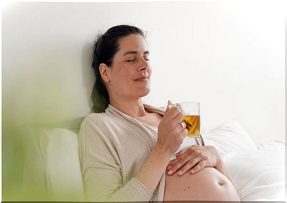 Woman drinking an infusion or green tea during pregnancy.