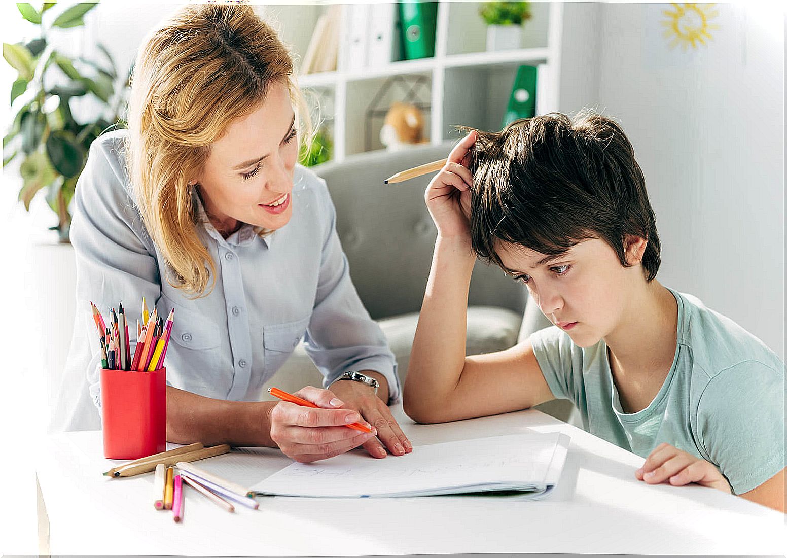 Boy working with his speech therapist because he has childhood dyslexia.