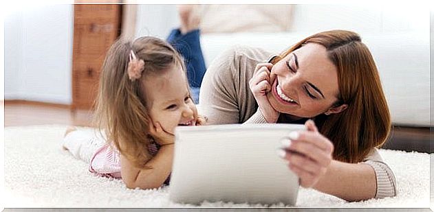 Mother with her daughter explaining good internet access with a tablet.