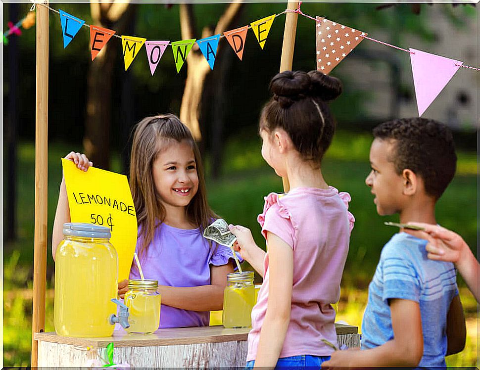 Girl selling lemonade at a stall as part of financial education activities.