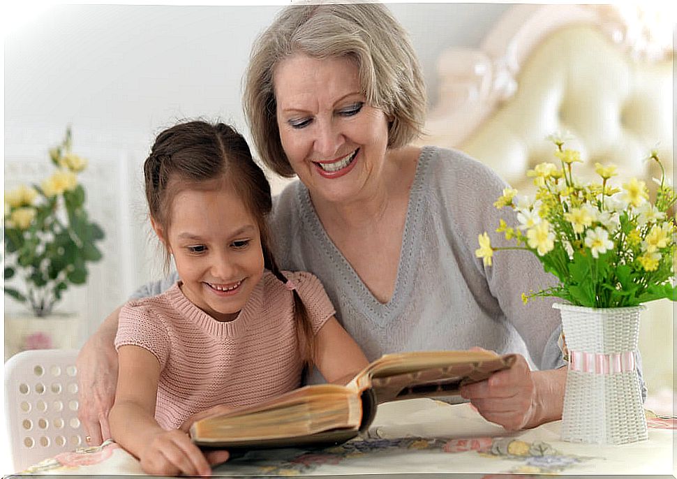 Grandmother reading a book with her granddaughter.