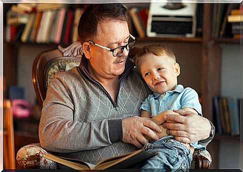 Grandfather reading a book to his grandson.