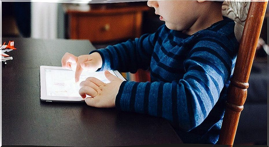 Child playing with a tablet at home.