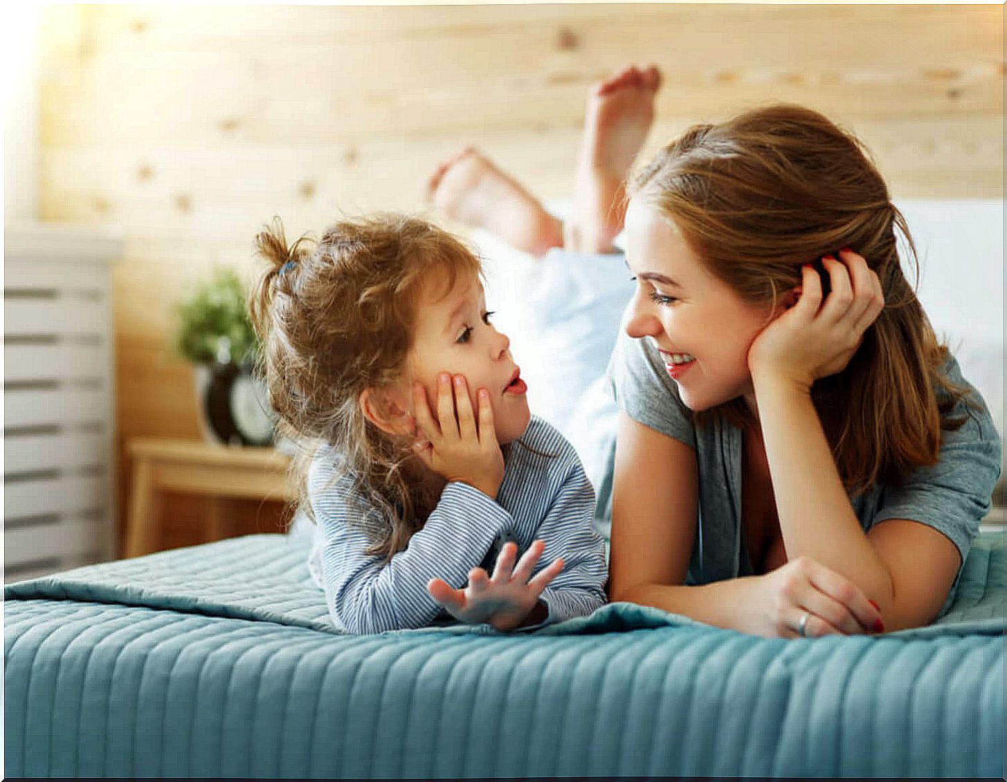 Mother having a conversation with her little girl and learning to speak so that her son thinks.