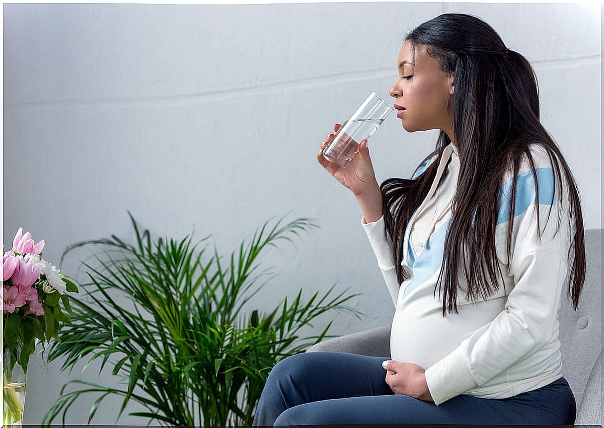 Pregnant woman drinking water.