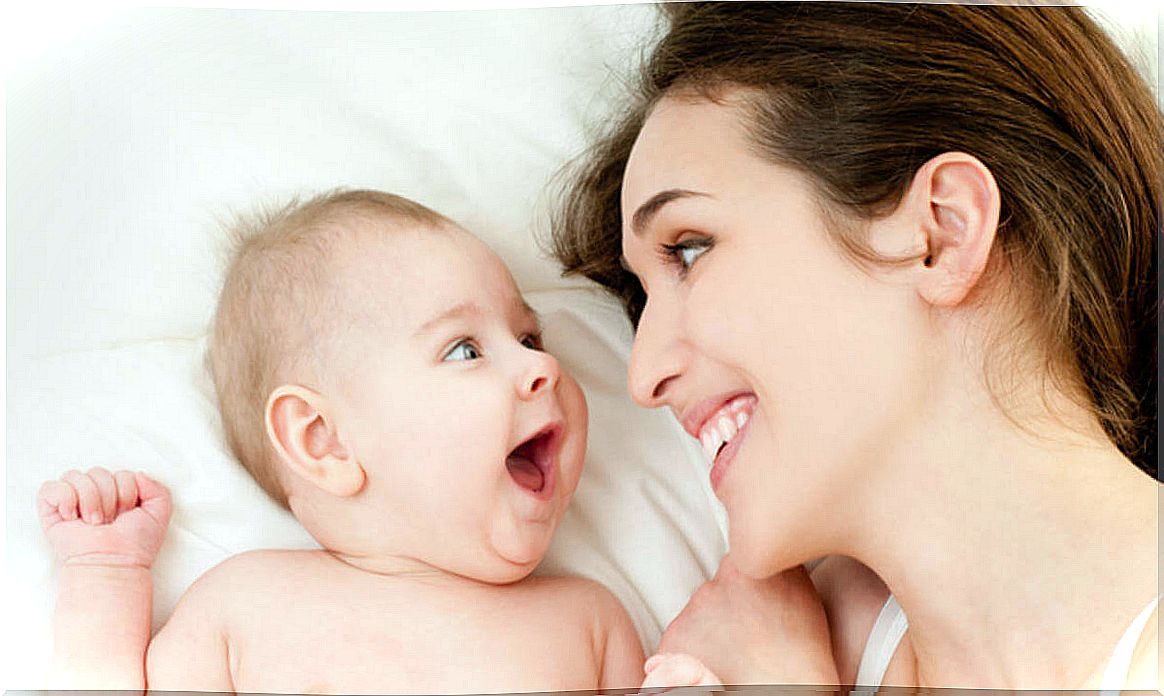 Mother in bed with her baby smiling