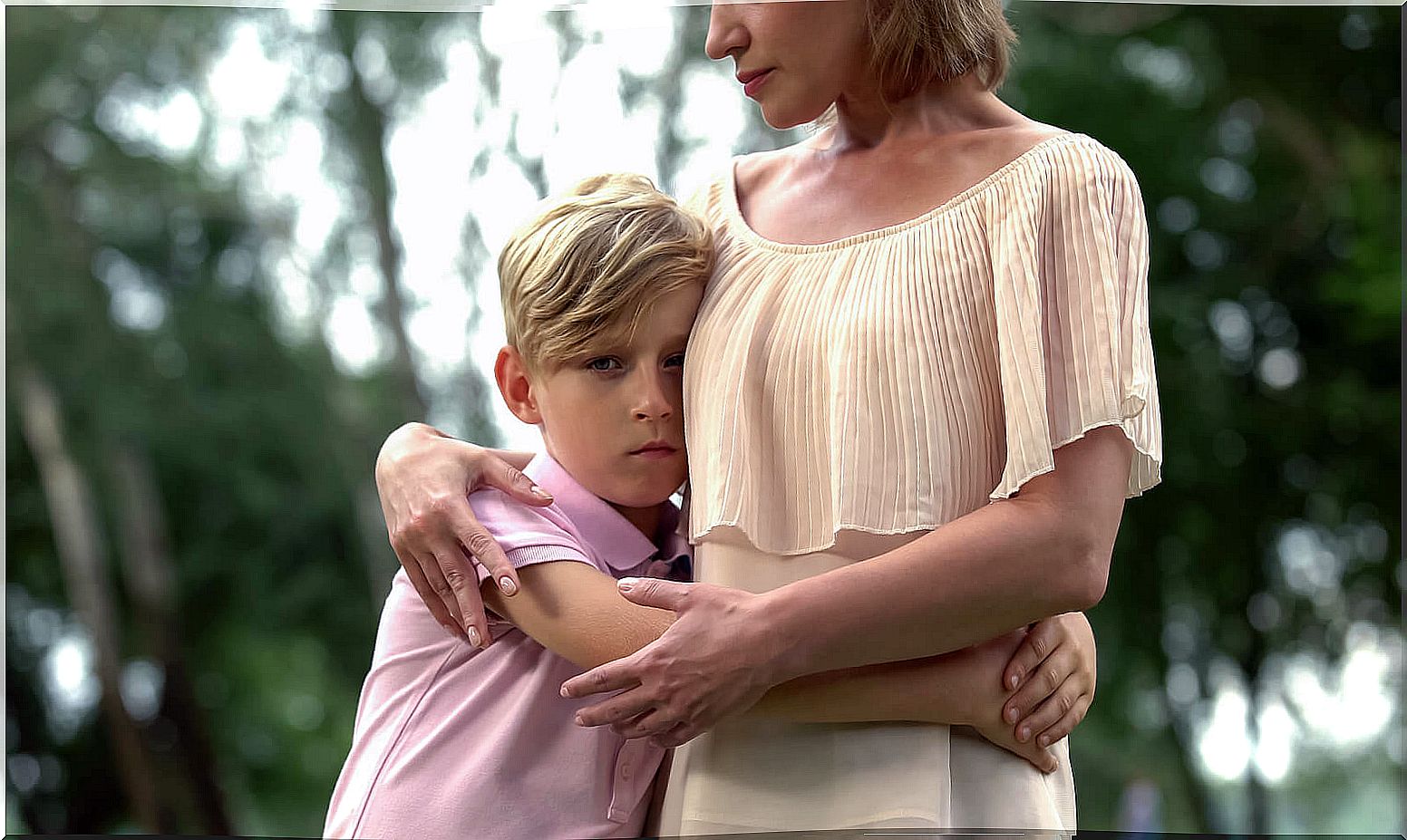 Son hugs his mother to show internalizing and externalizing symptoms.