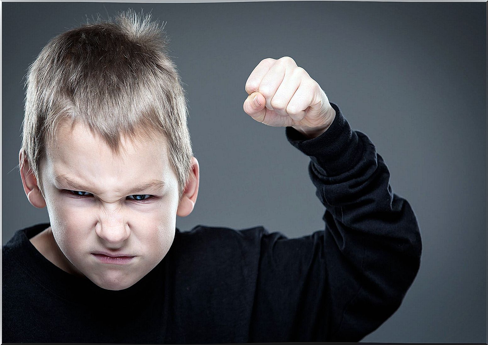 Child with raised fist ready to hit because he has become aggressive.