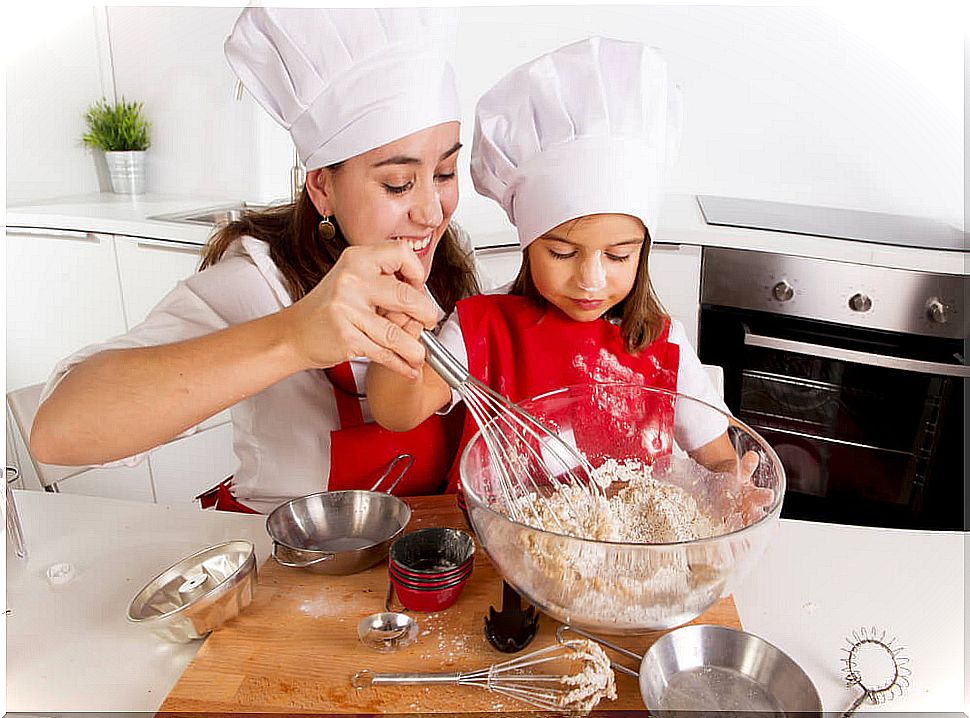 Little girl helping her mother cook.