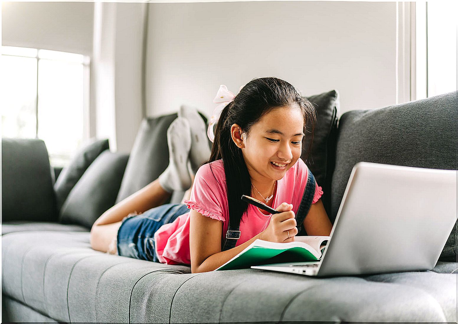 Girl studying on the couch applying self-regulation learning techniques.