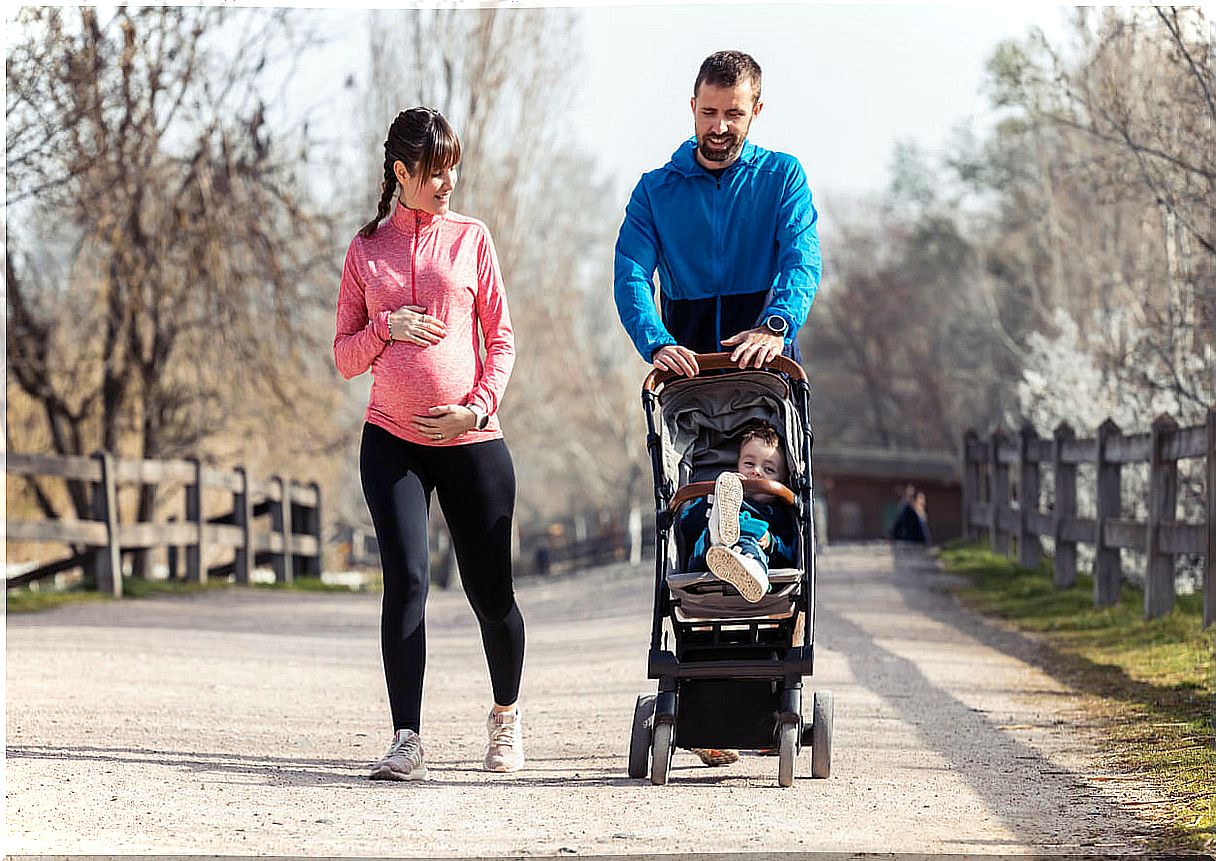 Couple practicing sport with their son in the stroller.