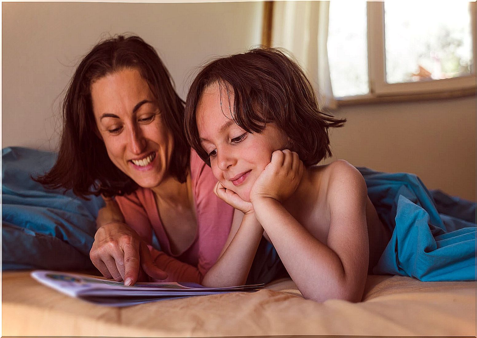 Mother reading a book to her son to encourage the development of critical thinking.