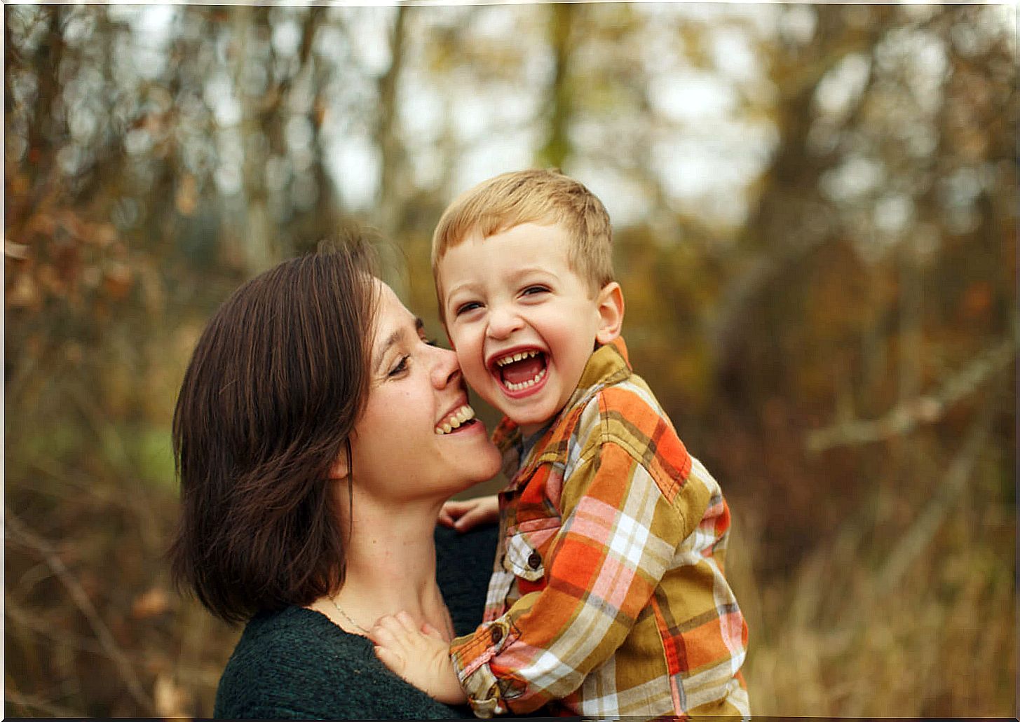 Mother giving a kiss and a hug to her son.