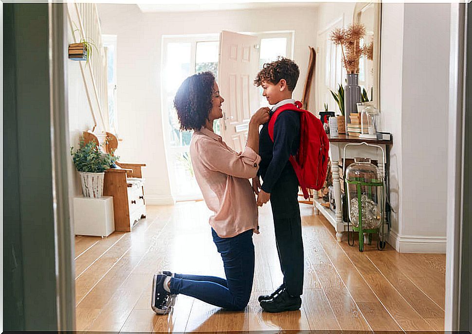 Mother preparing her son to go to school.