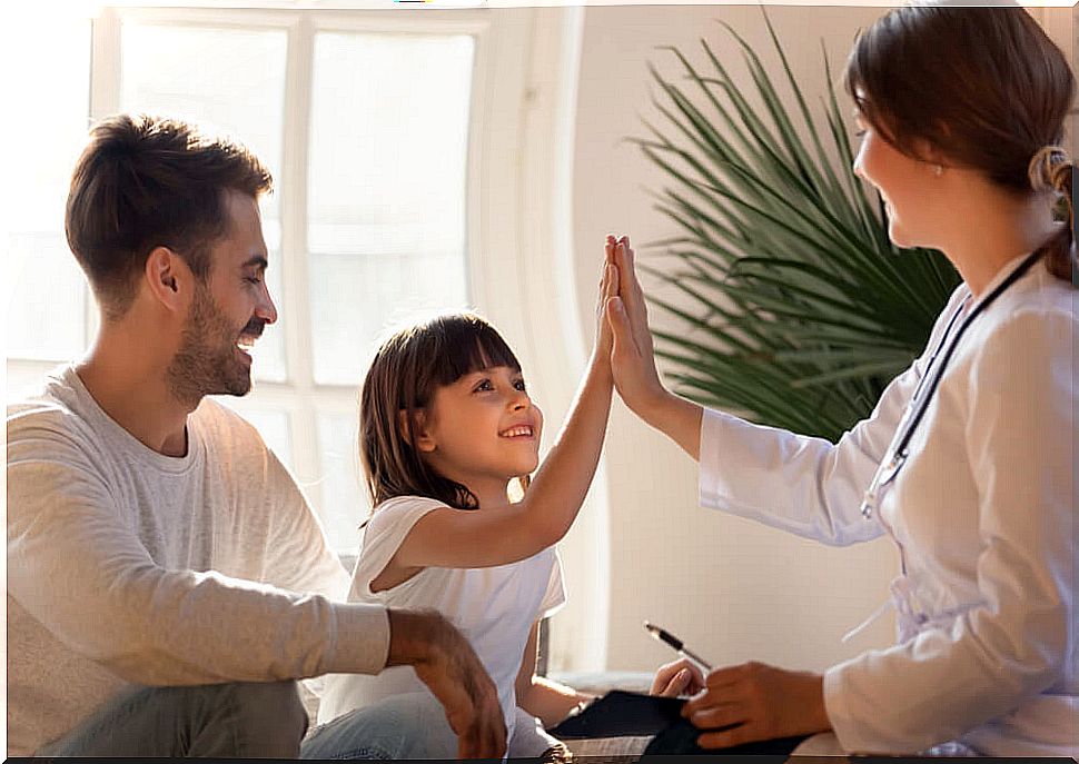 Little girl high-fiving her pediatrician after a checkup.