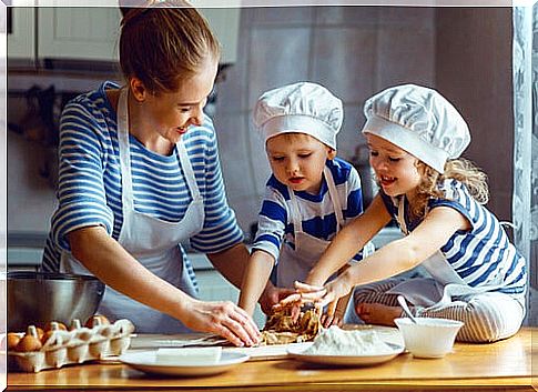 Mother and children preparing cookie dough in the kitchen.